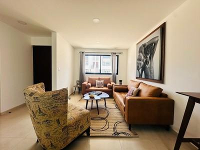 Sala tipo loft con sillones de piel
